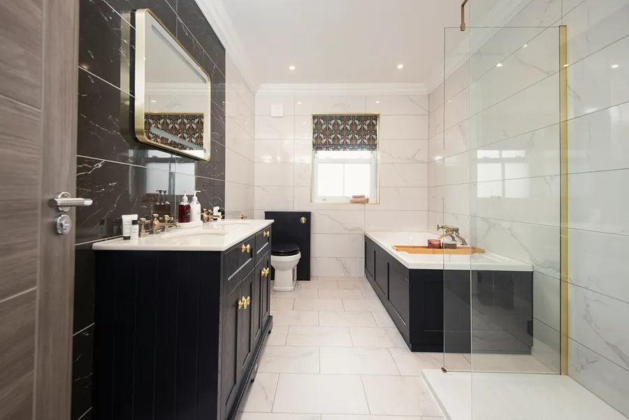 Bathroom with a dark vanity and marble-effect tiles